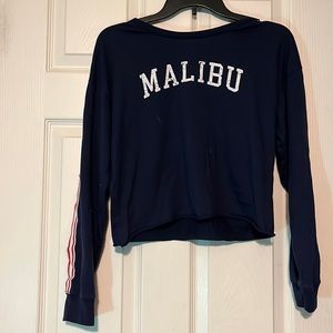 Medium navy blue long sleeved crop top with words “Malibu” by youth in revolt